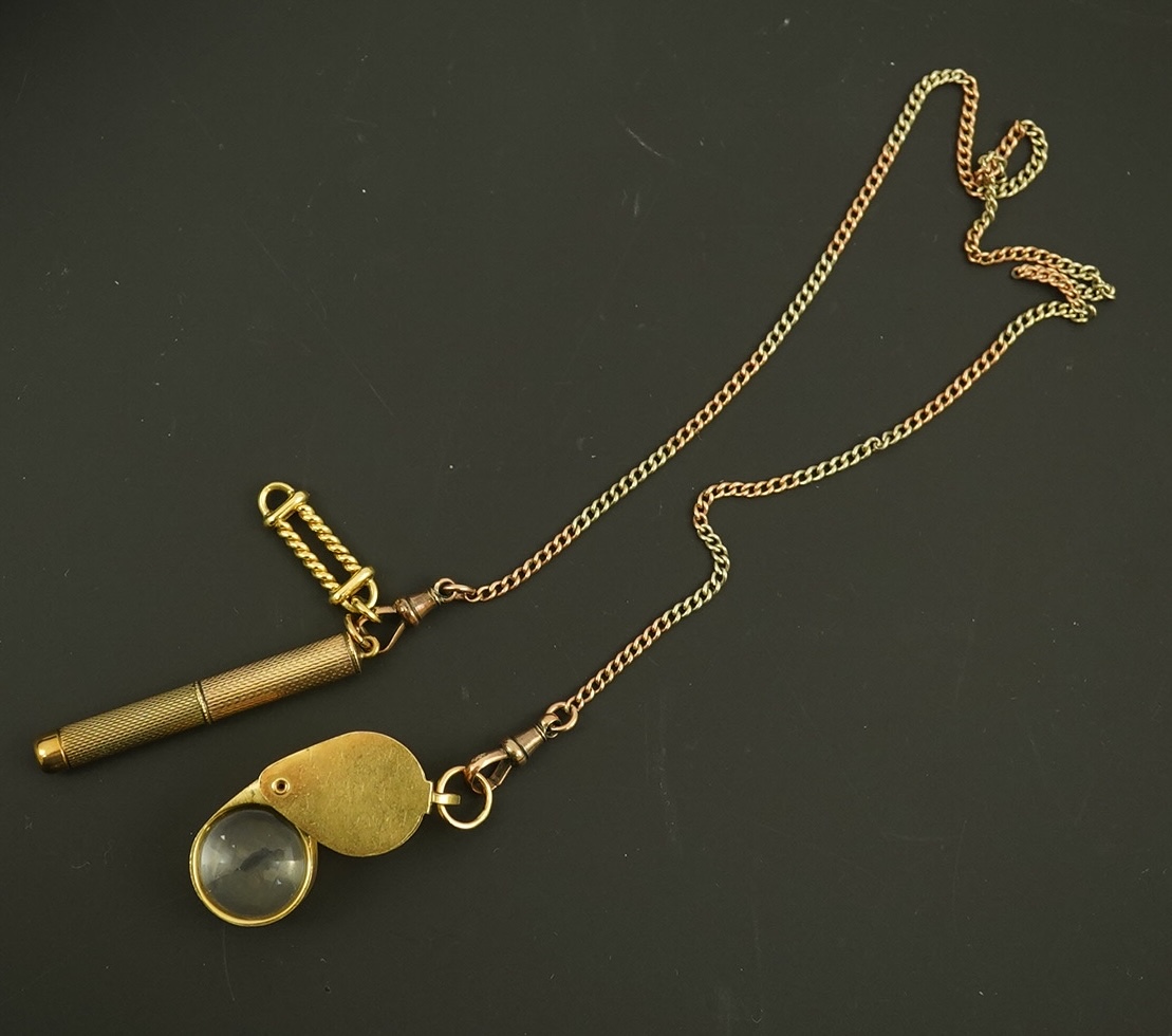 A modern 18ct gold mounted jeweller's loupe, 24mm and a 9ct gold cased propelling toothpick, both suspended from a two colour 9ct gold chain